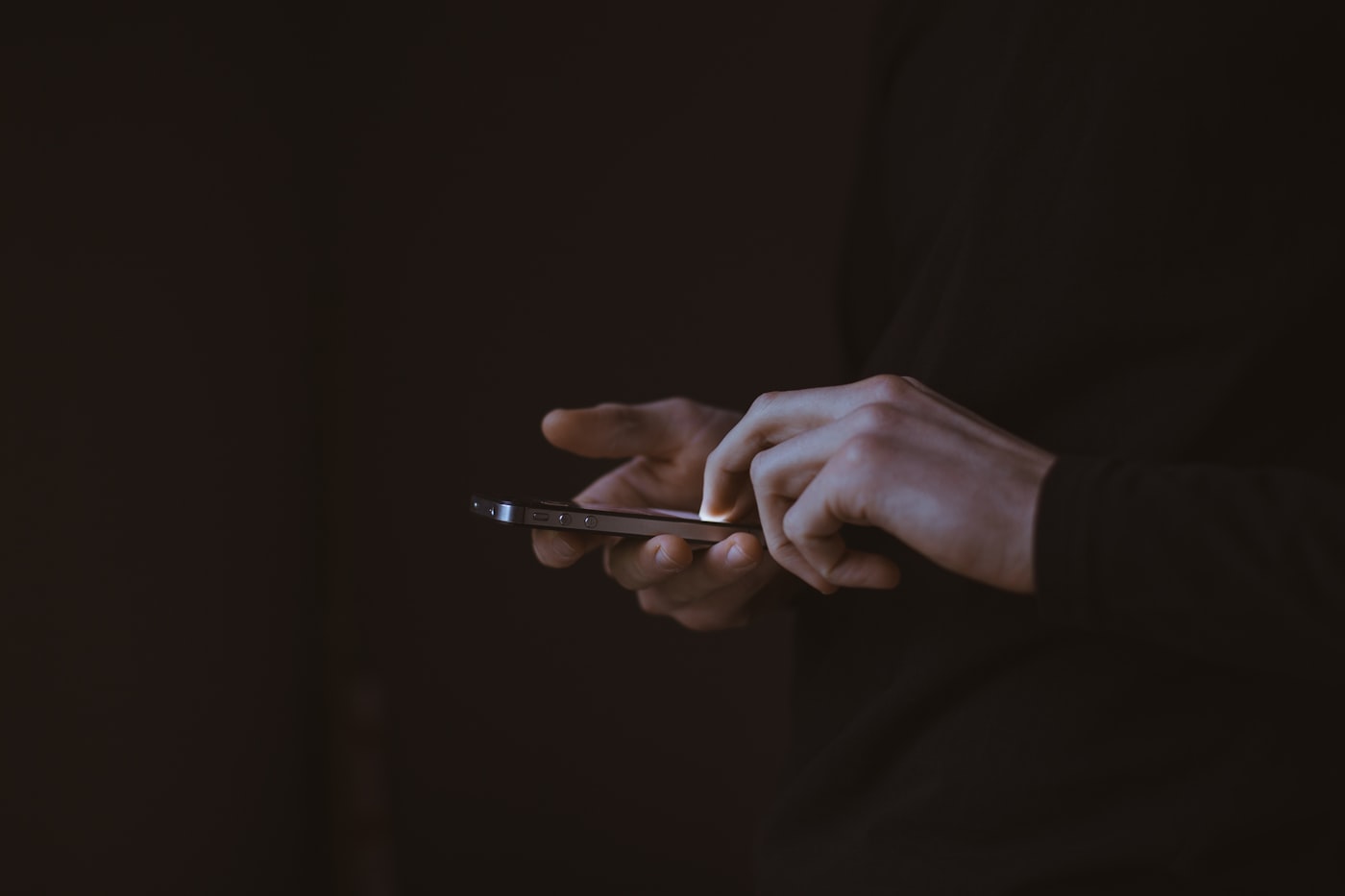 Person holding a phone to call an addiction helpline for support