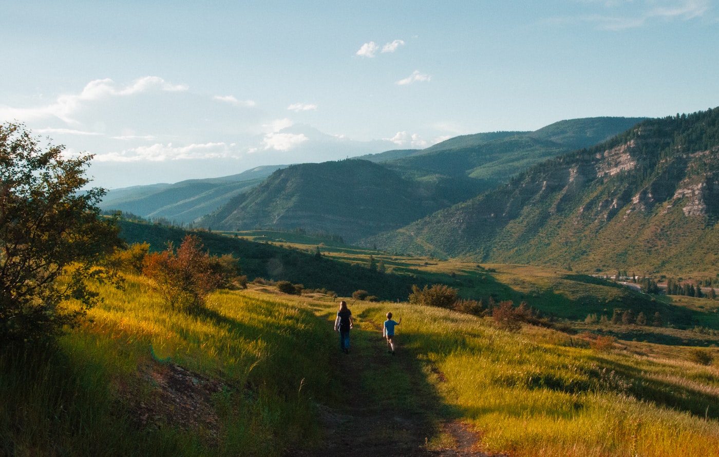 Family walking together along a peaceful nature trail in soft afternoon light