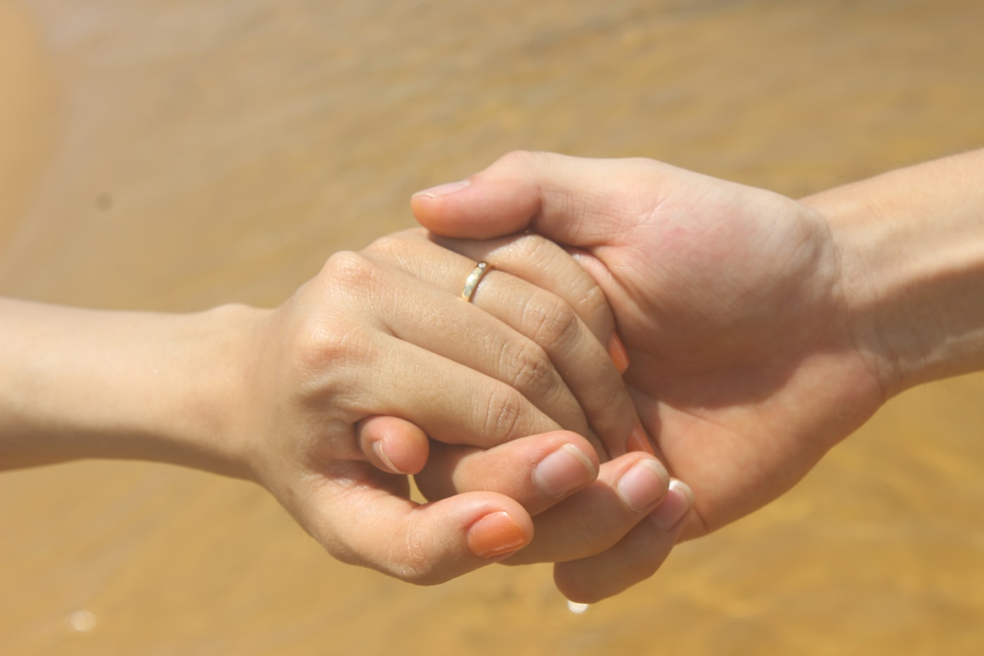 Two people holding hands in a gesture of support and reassurance