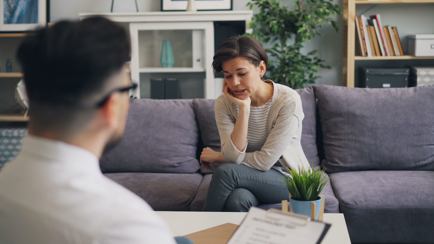 Person comparing inpatient and outpatient rehab options with a counselor
