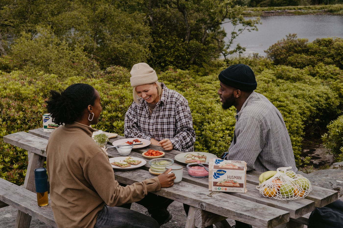 Diverse group of friends sharing a meal and laughing together outdoors