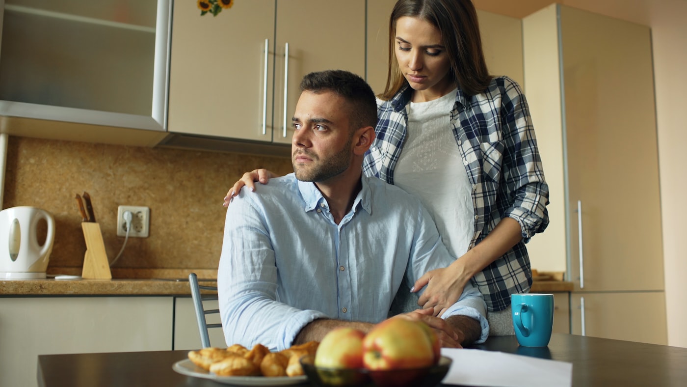 Parent and teenage child talking together at home