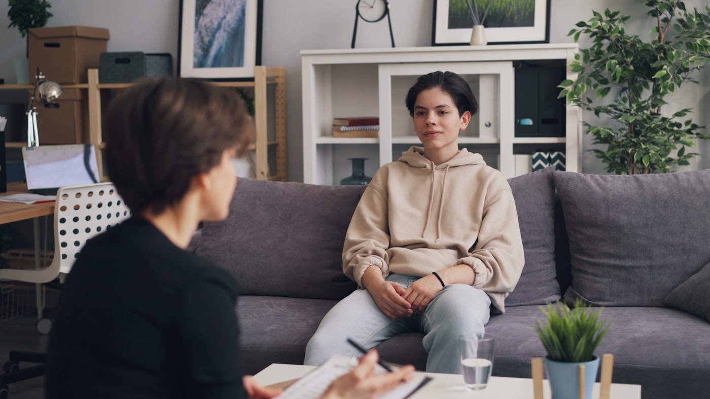Teenager talking with a youth counsellor in a supportive setting